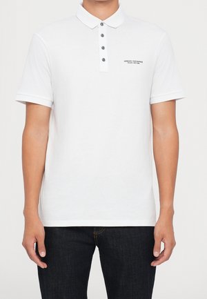 Weißes Polohemd mit Kragen und einer Knopfleiste mit drei Knöpfen. Mit kurzen Ärmeln, Markenlogo auf der Brust und einer glatten Baumwollstruktur.