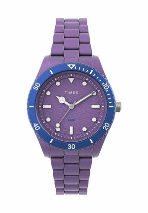 Orologio Timex viola con quadrante a motivi a onda, lunetta blu, lancette argentate e bracciale in metallo con design a maglie. Indicazione di impermeabilità.