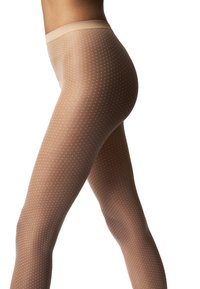 Gambe in collant trasparenti color nude con piccoli pois bianchi, viste di lato su sfondo bianco.