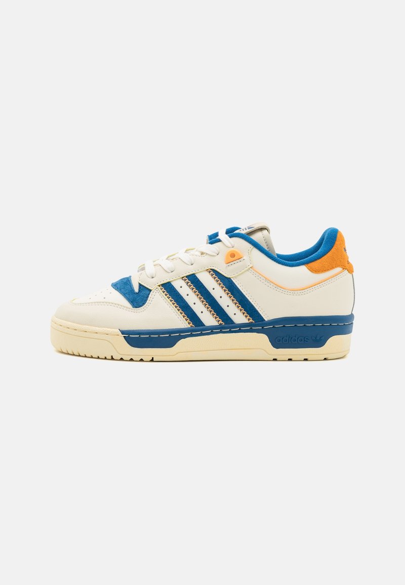 Weißes Leder-Sneaker mit blauen und orangefarbenen Akzenten, drei blauen Streifen, strukturiertem Zunge und cremefarbener Gummisohle. Auffällige Markenkennzeichnung auf der Ferse.