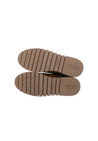 Semelles de chaussures en caoutchouc marron avec des rainures horizontales, présentant un logo en forme de cœur et le nom de la marque "CRICKIT" embossé sur la semelle intérieure.