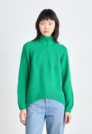 Green ribbed pullover sweater with a high collar and half zipper. Features long sleeves and a relaxed fit, with diagonal knit patterns.