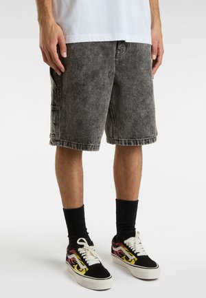 Shorts in denim nero con un motivo sbiadito, caratterizzati da una vestibilità comoda e orlo sfilacciato. Abbinati a scarpe nere con un design di fiamme colorate.