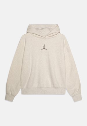 Jasnobeżowa bluza z kapturem i długimi rękawami, z małym czarnym logo Jumpman umieszczonym na środku klatki piersiowej.