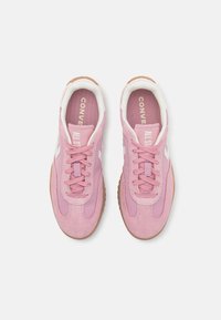 Rosa joggesko med overdel i semsket skinn og mesh, hvite detaljer, brun gummisåle, snørebånd i matchende rosa og "CONVERSE ALL STAR" merkevare innvendig.