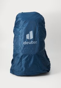Kék nylon hátizsák teteje matt felülettel. Jellegzetes fehér logóval rendelkezik, sima és könnyű anyaga az időjárás elleni védelem céljából készült.