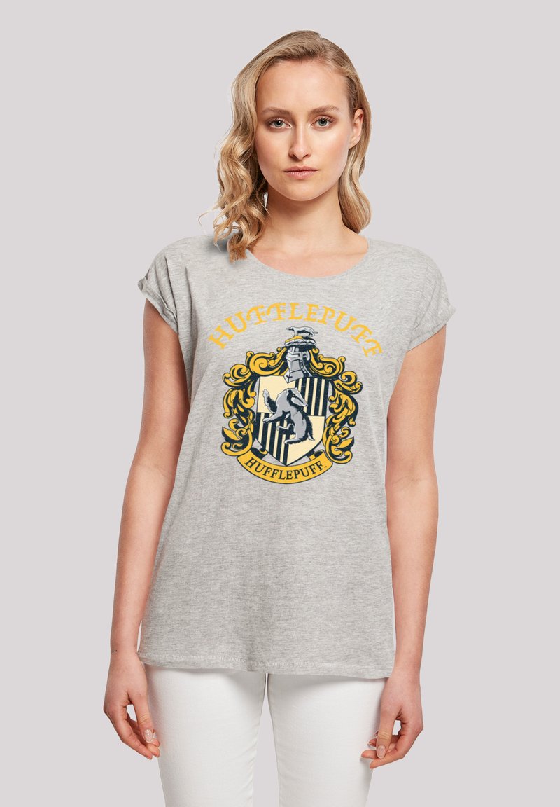 Grå bomulls T-skjorte med korte ermer som har et Hufflepuff-våpen i gult og svart, som viser et bor og dekorative elementer.