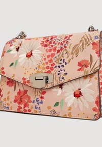 Sac à main floral en rose avec des fleurs brodées en rouge, blanc et vert. Dispose d'un fermoir métallique et d'une surface en tissu texturé.