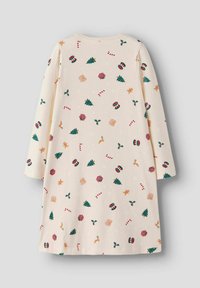 Kreacja z długim rękawem w kolorze kremowym, ozdobiona świątecznym wzorem pierniczków, choinek, lasek cukrowych i prezentów w czerwonych i zielonych odcieniach.