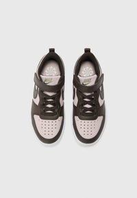 Nike tenisice s ružičastim sintetičkim tijelom, smešnim kožnim detaljima, perforiranim vrhom, smešnim vezicama i čičak trakama. Bijela potplat i logo.