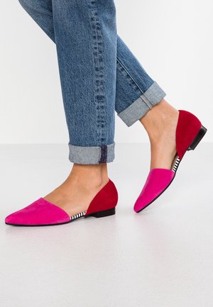 Tofarvede flade sko i pink og rød ruskind med en lav hæl, der har et kontrasterende stribemønster indvendigt i skoen.