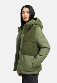 Groene buitenjack met een fluffy textuur aan het bovenpaneel, ritssluiting, capuchon en zijzakken. Glad stof met een warme, gewatteerde design.
