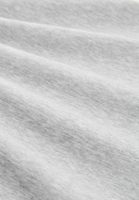 Šviesiai pilka medžiaga su lygiomis tekstūromis, turinčia subtilių spalvų variacijų ir minkštų raukšlių, sukurianti banguotą išvaizdą.