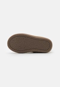 Talpa texturată de culoare maro cu un model ondulat, concepută pentru aderență. Prezintă o formă plată, potrivită pentru încălțăminte casual. Fără branding sau accente vizibile.
