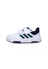 White athletic shoe with navy accents, featuring two Velcro straps and three green diagonal stripes on the side. Rubber sole and textured detail.