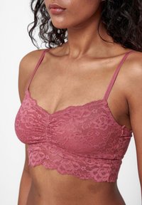 Spitzen-Bralette in staubigem Rosé mit verstellbaren Trägern. Bietet eine geraffte Textur auf der Vorderseite und einen gewellten Spitzenabschluss.