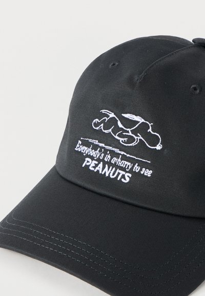 Μαύρο καπέλο μπέιζμπολ με λευκή κεντημένη εικόνα του Snoopy να ξαπλώνει και κείμενο "Όλοι βιάζονται να δουν τα PEANUTS" μπροστά.