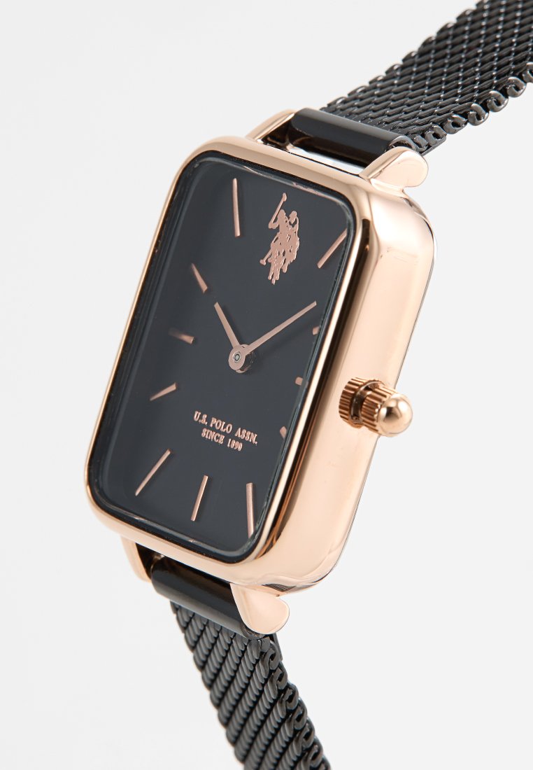 Rechteckige schwarze Uhr mit rose-goldenen Akzenten, ausgestattet mit einem Mesh-Armband und einer manuellen Krone. Logo auf dem Zifferblatt angezeigt.