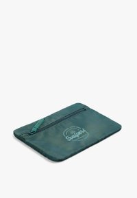Bolsa textil verde con un acabado texturizado, que cuenta con un cierre de cremallera en la parte superior y un logo impreso en el centro. Forma compacta y rectangular.