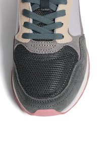 Sneaker con materiali in rete grigia e camoscio, dotata di lacci color teal, una finitura beige, forma arrotondata e suola in gomma rosa.