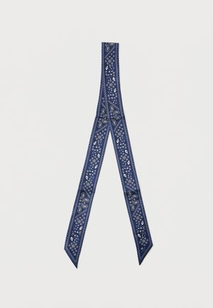 Écharpe étroite bleu marine avec motifs cachemire blancs et motifs géométriques, portée en boucle pliée sur fond blanc.