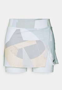 Falda blanca con un patrón geométrico abstracto en colores claros, superpuesta sobre unos pantalones cortos ajustados. Presenta un logo de Nike en el lateral.