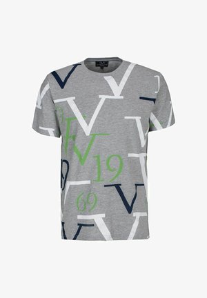 T-shirt grigia a maniche corte con grandi lettere sovrapposte "V" in bianco, blu navy e verde, e numeri verdi "19" e "69" stampati sul tessuto.