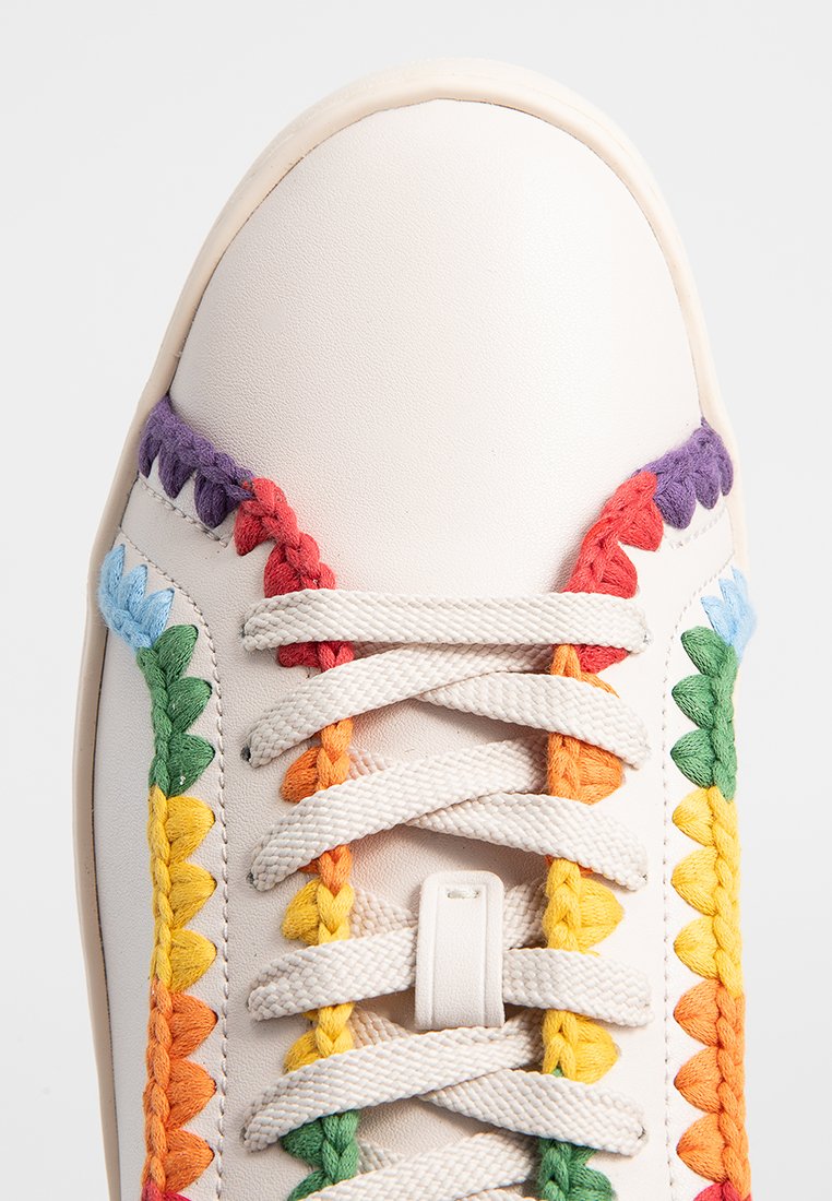 Weißer Sneaker mit mehrfarbigen aufgestickten Blumenmustern an den Seiten. Die Schnürsenkel bestehen aus strukturiertem Stoff und die Oberfläche ist glatt.