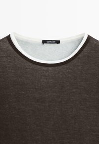 Dunkelbraunes Rundhalsshirt mit weißer Innenverkleidung am Kragen und einem innen eingenähten "Massimo Dutti"-Etikett.