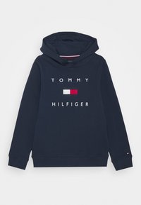 Granatowy polar z kapturem wykonany z bawełny, z białym i czerwonym logo "TOMMY HILFIGER" na przodzie oraz prostokątnym wzorem kolorowym poniżej.