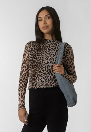 Leopardenmuster langärmliges Oberteil, durchsichtiger Stoff, taillierte Passform, Rundhalsausschnitt, kombiniert mit einer Jeans-Schultertasche. Schwarze Hose vervollständigt das Outfit.