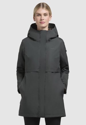 Veste à capuche noire avec fermeture éclair, dotée de deux poches latérales, d'une coupe mi-longue et d'un logo discret sur la poitrine. Doublure texturée visible dans la capuche.