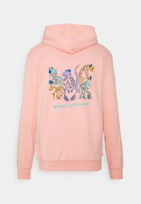 Rosa hoodie med ett fronttryck av dinosaurieskelett i blått, gult och grönt. Ribbstickade muddar och fåll. "adidas Originals" tryckt nedanför.