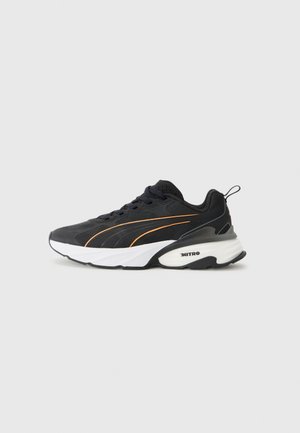 Black athletic shoes with orange accents, mesh and synthetic upper, cushioned midsole, and rubber outsole with textured design.