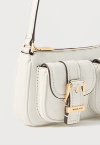 Bolso de mano de cuero blanco con superficie texturizada, herrajes dorados y ribetes oscuros. Incluye un detalle de hebilla y una silueta estructurada.