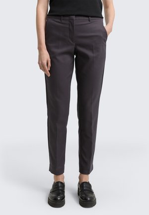 Mørkegrå skreddersydde bukser med slim fit, med en glatt tekstur, frontfolder og flat midje. Kombinert med svarte loafers.