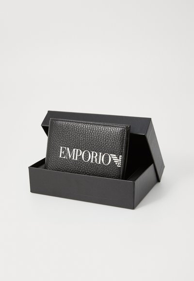 Melnas ādas maciņš ar teksturētu virsmas apdari, ar "EMPORIO" logo baltajā krāsā, pasniegts melnā taisnstūra kastē.
