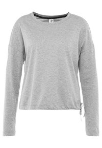 Grå långärmad topp i mjukt och lätt material. Har en avslappnad passform, rundad halsringning och dragskoDetalj vid nederkant.