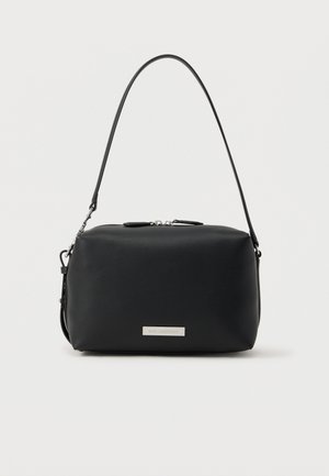 Sac à main rectangulaire en cuir noir avec une bandoulière unique et une fermeture éclair argentée, comportant une petite plaque de marque argentée sur le devant.