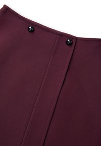 Bordeaux rok van een gladde, textuurstof, met twee zwarte knopen in de tailleband en naaddetails aan de achterkant.
