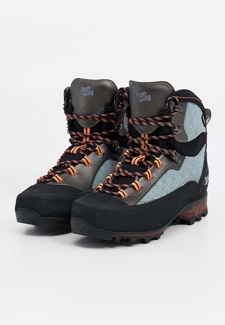 Para czarnych i szarych butów turystycznych Hanwag z pomarańczowymi i czarnymi sznurowadłami na białym tle.