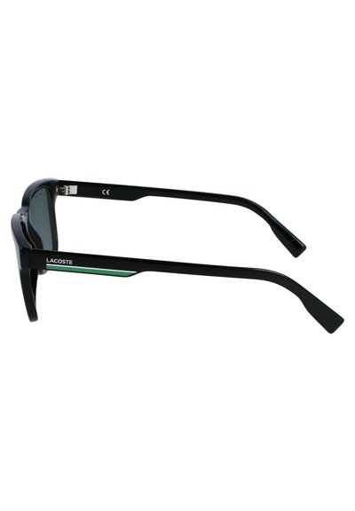 Lunettes de soleil en plastique noir avec des verres teintés. Les branches présentent une bande d'accent verte et un logo, avec un design élégant et angulaire.