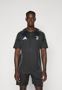 Black athletic shirt featuring short sleeves, light blue accents, and pink piping. Adidas logo and Juventus emblem on the chest.