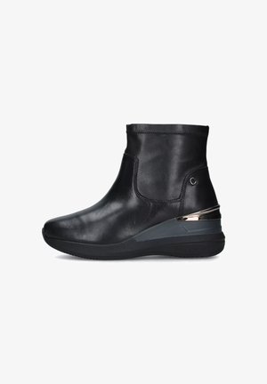 Stivale alla caviglia in pelle nera con punta rotonda, design elegante e un accento grigio e metallico a contrasto sul tallone. Suola piatta per il massimo comfort.