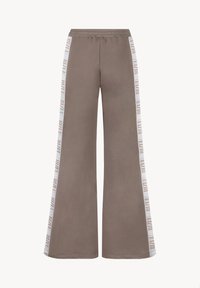 Lange sweatpants in lichtbruin katoen met een trekkoord in de taille. Heeft witte zijstrepen met merknaam in een bruin lettertype.