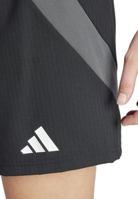 Zwarte sportshorts met verticale strepen, voorzien van een grijze diagonale streep en een wit Adidas-logo op de zoom. Gestructureerde stof.