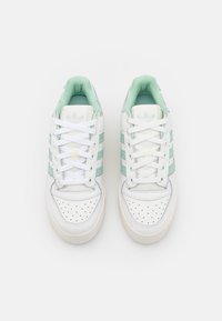 Vita sneakers med perforerat tå, mintgröna accenter, texturerad ovandel och snördesign med tre ränder på sidorna.