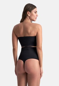 Schwarzer, trägerloser Bikini-Oberteil kombiniert mit hochgeschnittenen Unterteilen, die über eine glatte Textur und ein minimalistisches Design ohne zusätzliche Verzierungen verfügen.