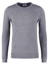 Šedý pletený svetr s kulatým výstřihem a dlouhými rukávy. Má žebrované manžety a lem, s malým logem na levé straně hrudi.