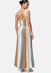 Robe maxi en tricot avec des rayures verticales bleu, brun, crème et blanc. Dotée d'un dos dégagé et d'une conception sans manches. Matière douce et extensible.